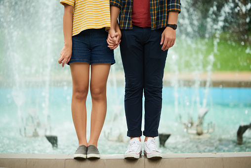 Cropped image of young couple holding hands
