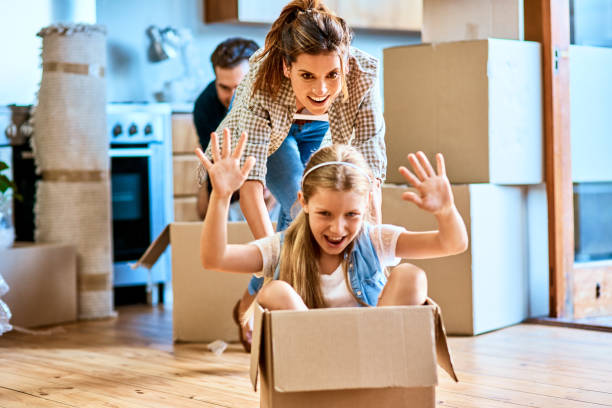 Time to go on an adventure! Shot of a cheerful young woman pushing her daughter around in a box imagining its a car inside at home during the day mum new boyfriend stock pictures, royalty-free photos & images