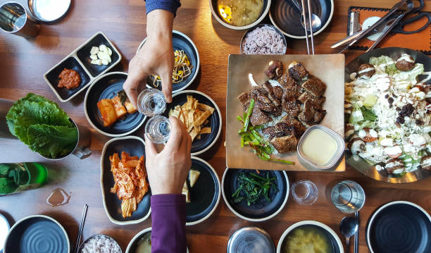 compartir buena comida y vino con el amigo - korean culture fotografías e imágenes de stock