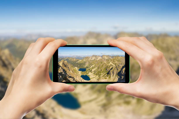istock Photographing mountain landscapes using a smartphone. Hands holding a mobile phone. 949082978