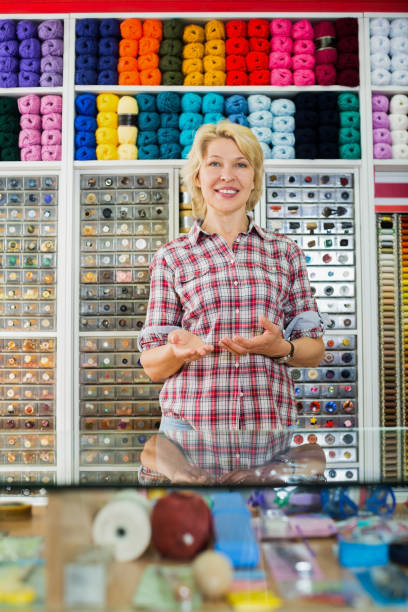 istock Shopkeeper woman offering sewing tools 949086166