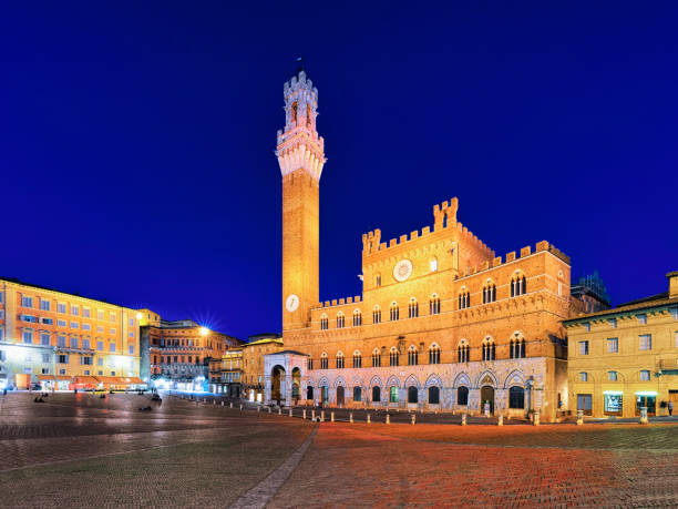 Torre del Magnia Tower on Piazza Campo Square Siena dusk Torre del Magnia Tower on Piazza Campo Square in Siena, Tuscany, Italy. Late in evening torre del mangia stock pictures, royalty-free photos & images