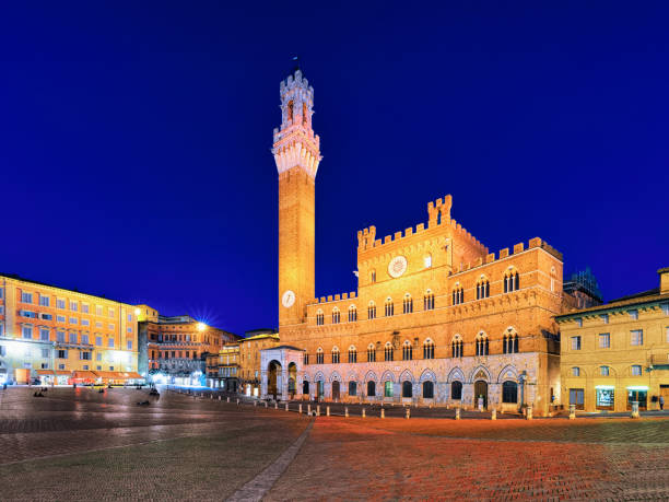 башня торре-дель-магния на площади пьяцца кампо сиена сумерки - palazzo pubblico стоковые фото и изображения