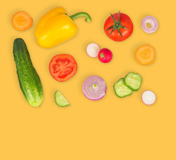 istock Vegetable mix on orange isolated background. Fresh yellow pepper, chopped tomatoes, onion, round cucumber slice, carrot, radish. The concept of a healthy lifestyle. Vegetarian food. 949090200