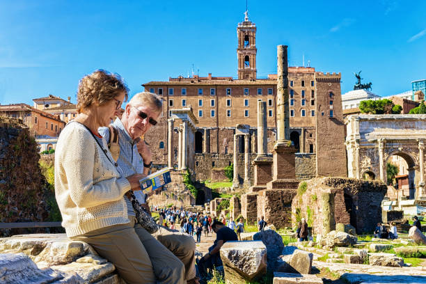 Rome, Italy - October 12, 2016: People reading touristic guide book at Roman Forum in Rome in Italy.