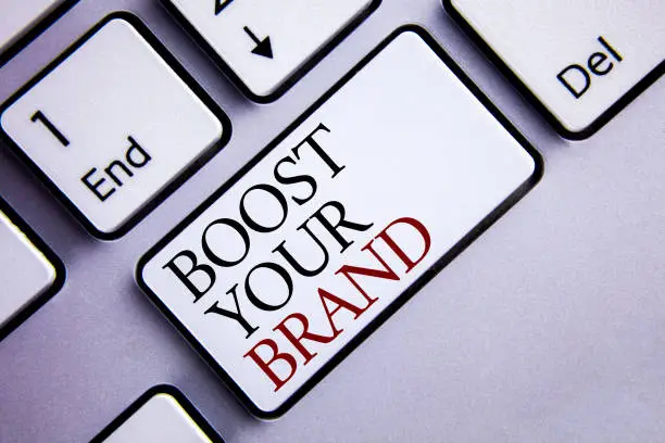 Photo of Word writing text Boost Your Brand. Business concept for improve your models name in your field overcome competitors written on White Keyboard Key with copy space. Top view.