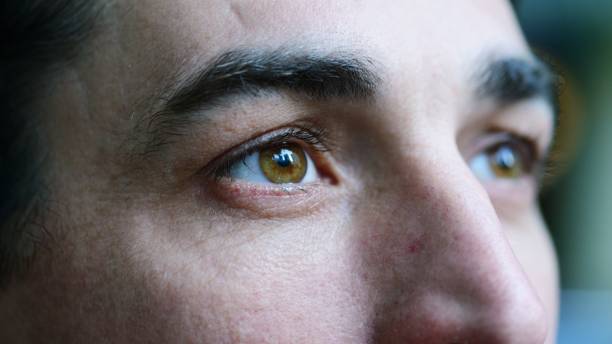 Closeup portrait of mid adult man A closeup portrait of a mid adult man looking away from the camera. eye closeup stock pictures, royalty-free photos & images