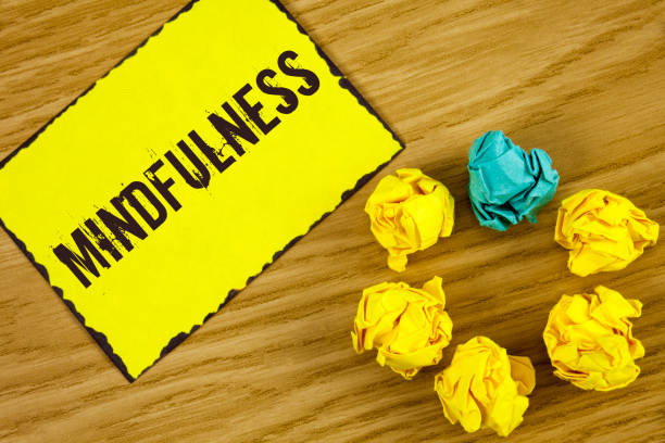 istock Handwriting text Mindfulness. Concept meaning Being Conscious Awareness Calm Accept thoughts and feelings written on Sticky Note paper on wooden background Crumpled Paper Balls next to it. 949103084