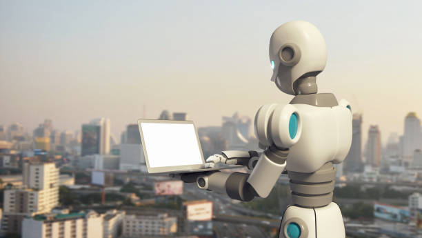 istock Robot using a laptop computer with blank screen in city, artificial intelligence in futuristic technology concept, 3d illustration 949103940