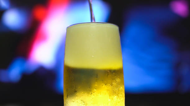 Beer is pouring from the top into a pint glass.
