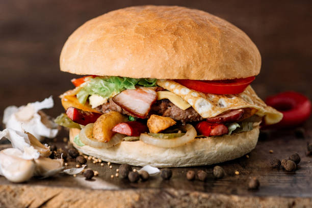 istock fresh tasty burger with omelet on wooden table 949107182