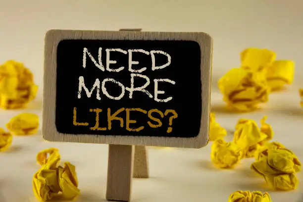 Photo of Text sign showing Need More Likes Question. Conceptual photo Improve reach Ads Marketing SEO Marketing Improve written on Wooden Notice Board on the plain background Yellow Paper Balls.