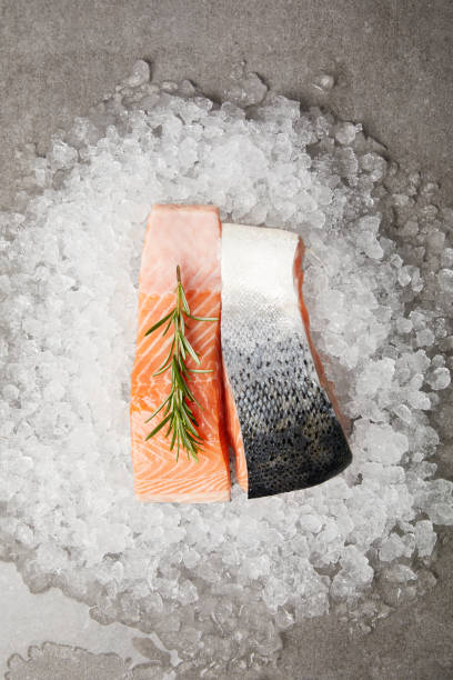 вид на нарезанное филе лосося с розмарином на дробленом льду и на бетонной поверхности - freshness seafood crushed ice salmon стоковые фото и изображения