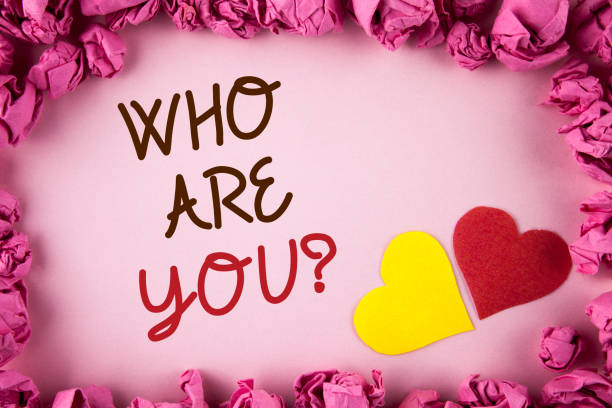istock Word writing text Who Are You Question. Business concept for Introduce or Identify Yourself Tell your Personal Story written on plain background within Pink Paper Balls Hearts next to it. 949119228