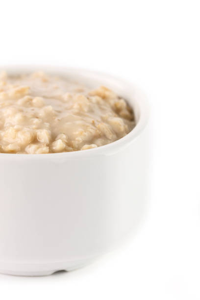istock breakfast: oatmeal porridge in white bowl on white background. Isolated 949123078