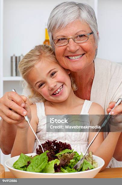 Photo libre de droit de Heureuse Grandmère Et Petitefille Mangeant Une Salade banque d'images et plus d'images libres de droit de Adulte