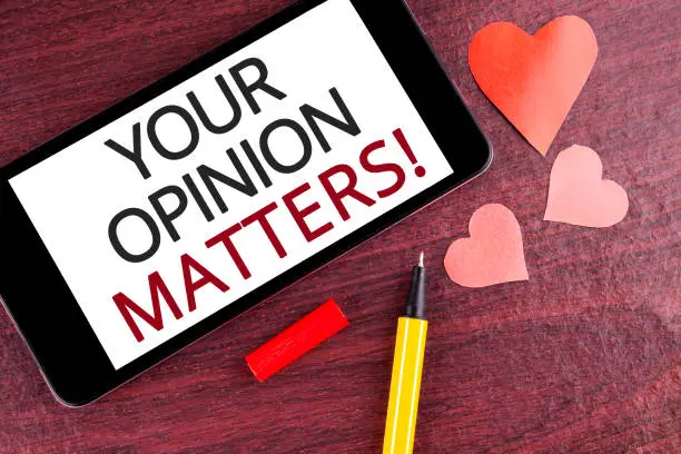 Photo of Writing note showing  Your Opinion Matters Motivational Call. Business photo showcasing Client Feedback Reviews are important written on Mobile Phone Screen on wooden background Pen and Hearts