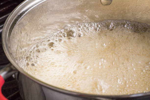istock Boiling and bubbling liquid closeup in pot 949134392