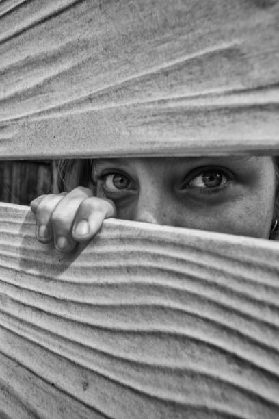 istock Woman peeks through the neighbours fence 949143384