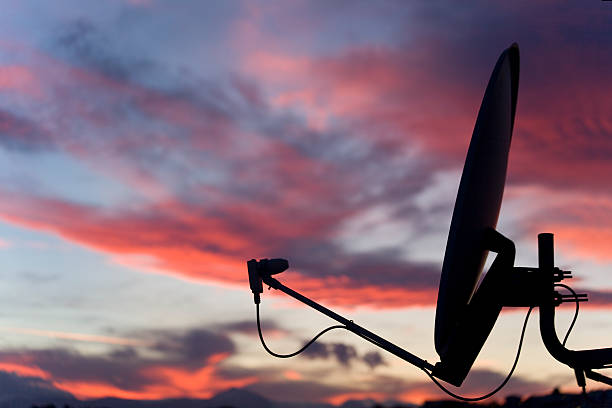 a satellite dish in front of a sunset sky  - uydu çanağı fotoğraflar stok fotoğraflar ve resimler