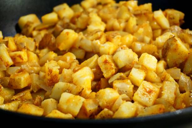 istock Frying potato hash in a frying pan 949159652