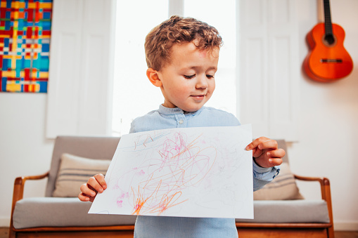 Caucasian boy showing drawing on paper