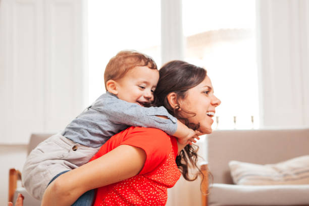 istock Playful mom carries her son on her back 949167088