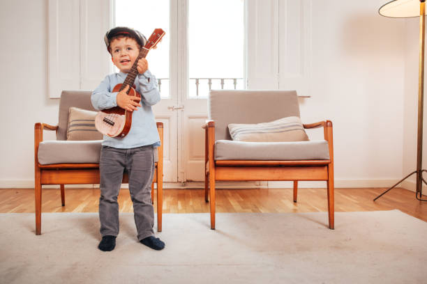 istock Child playing a ukulele in a living room 949167590