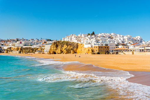 Wide, sandy beach in white city of Albufeira by Atlantic Ocean, Algarve, Portugal
