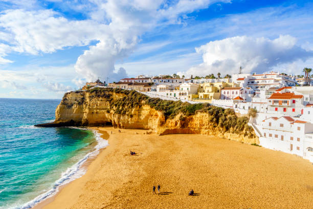 Sandy beach between cliffs and white architecture in Carvoeiro, Algarve, Portugal Wide sandy beach between cliffs and in front of charming white architecture in Carvoeiro, Algarve, Portugal algarve stock pictures, royalty-free photos & images