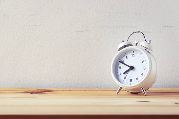istock retro alarm clock on wood table 949170566