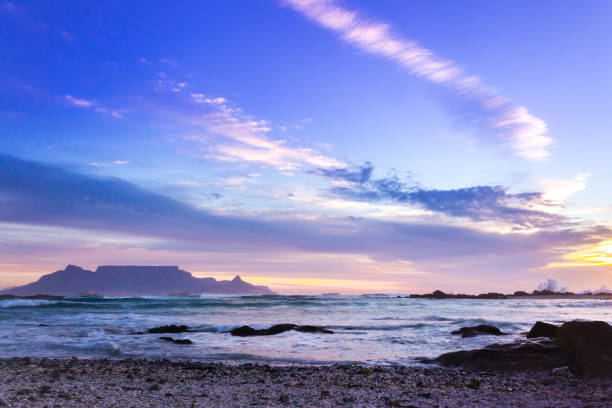 view of table mountain from milnerton beach at sunset, cape town, south africa. - milnerton imagens e fotografias de stock