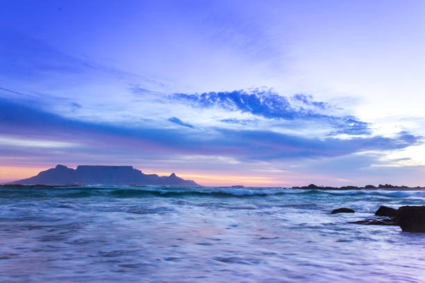 view of table mountain from milnerton beach at sunset, cape town, south africa. - milnerton imagens e fotografias de stock