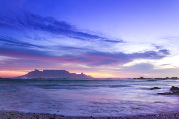 view of table mountain from milnerton beach at sunset, cape town, south africa. - milnerton imagens e fotografias de stock