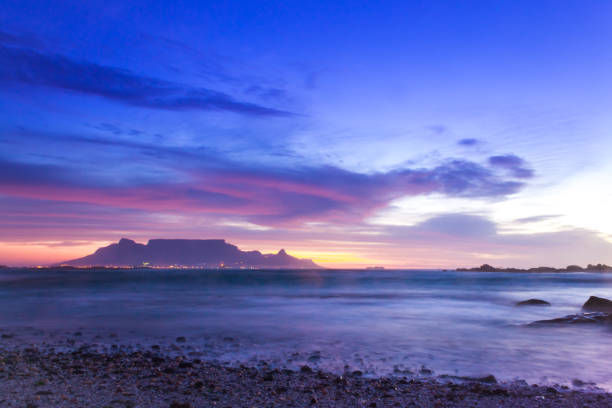 view of table mountain from milnerton beach at sunset, cape town, south africa. - milnerton imagens e fotografias de stock