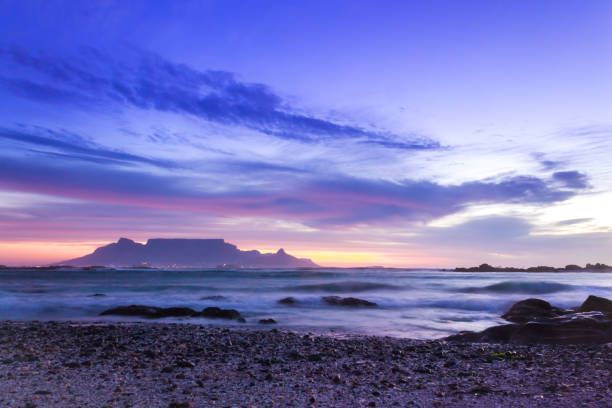 view of table mountain from milnerton beach at sunset, cape town, south africa. - milnerton imagens e fotografias de stock