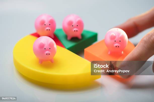 Person Placing Last Piece Into Pie Chart With Piggy Bank Stock Photo - Download Image Now