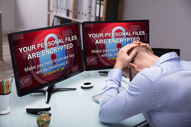 Stressed Businessman Sitting In Office Stressed Businessman Sitting In Office With Computer Screen Showing Personal Files Encrypted Text ransomware photos stock pictures, royalty-free photos & images