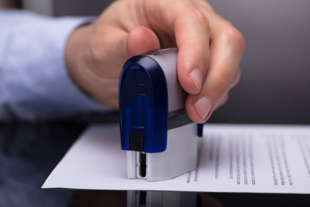 Businessperson Stamping Document Close-up Of A Businessperson's Hand Stamping Document beatification stock pictures, royalty-free photos & images