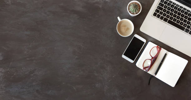 istock Top view of office desk on dark textured background 949182914