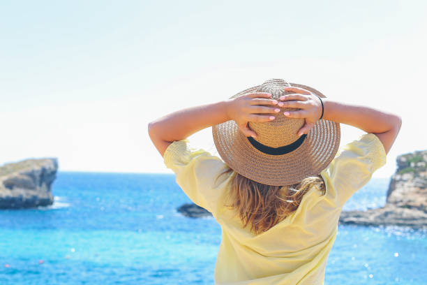 istock Women with hat lookiing at sea 949186358