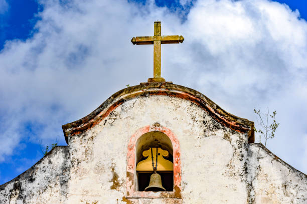 bell und kruzifix auf alte kapelle - church bell tower temple catholicism stock-fotos und bilder