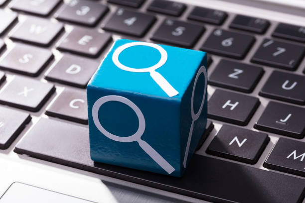 istock Magnifying Glass Symbol Block Over The Laptop Keypad 949187352