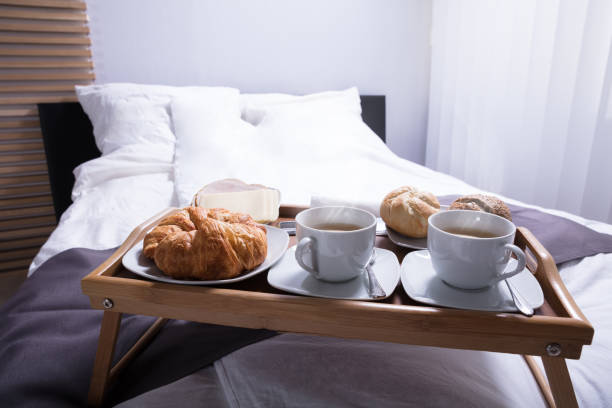 istock Croissants And Cup Of Tea On Bed 949189848