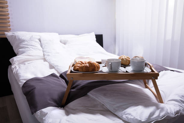 istock Croissants And Cup Of Tea On Bed 949189860