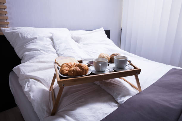istock Croissants And Cup Of Tea On Bed 949189870