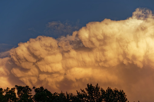 A storm cloud approaching near sunset