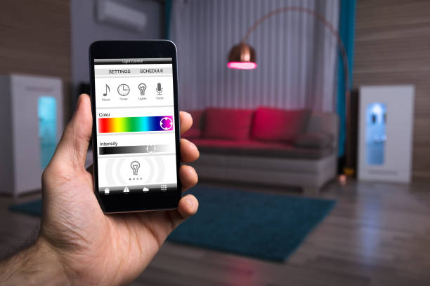 istock Human Hand Adjusting Electric Light Through Mobile Phone 949190198