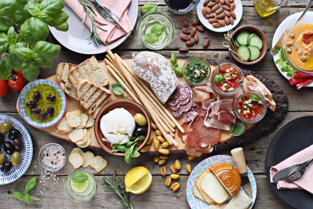 istock Mediterranean appetizers table concept. Diner table with tapas selection: cured meat and salami, gazpacho soup, jamon, olives, cheese, hummus and vegetables. 949190602