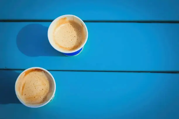 two cardboard cups of coffee on a blue background, a street coffee shop.
